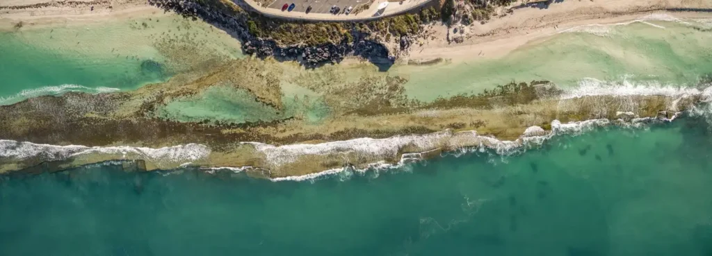 Aerial view of ocean waves and rocky shoreline