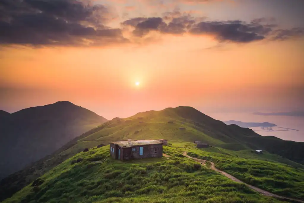 Small cabin on a hill during sunset