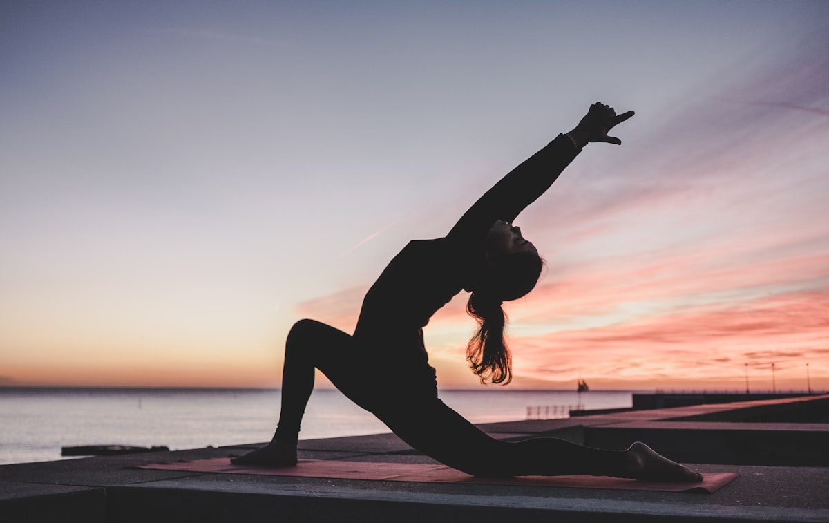 A senior practicing yoga on a Costa Rica beach for tropical wellness and longevity